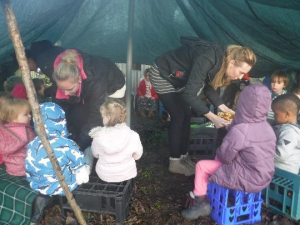 children in forest school shelter