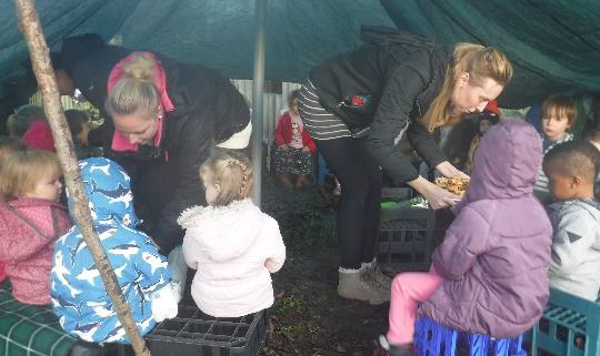 children in forest school shelter