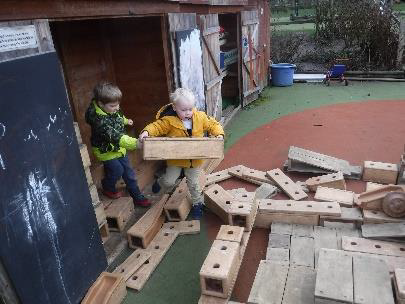 boys carrying blocks out of shed